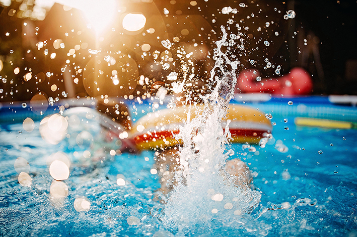 Schwimmbecken mit Schwimmreifen und spritzendem Wasser.