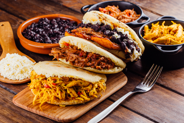 Arepas mit verschiedenen Füllungen wie Hühnchen, Fleisch, schwarzen Bohnen und gebratenen Kochbananen.