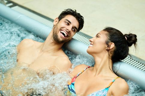 Glückliches Paar im Gespräch in einem Thermalbad.